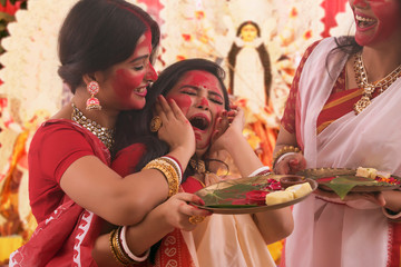 Two Bengali women playing vermilion sindur khela on the day of dashami
