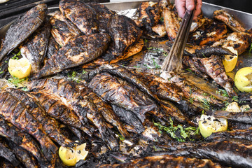 Freshly grilled fish on counter top stall, during seafood festival, street food market.