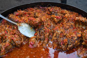 Traditional fish stew being prepared in a rustic bowl over a wood background.