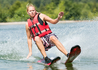 Sportliche Frau beim Wakeboarden fällt ins Wasser