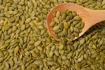 Peeled Pumpkin Seeds. Unshelled kernels. Nuts lie in a wooden spoon.
