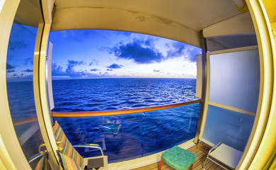 Fototapeta premium Ocean view from a cruise ship room balcony at sunset. Vacation and relax concept