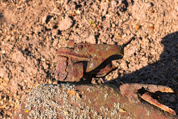 Close-up view of narrow neck of old smashed rusty jerrican. Old rusty metal surface with moss of jerrican on the ground. Rust destroyed the bottom of the jerrican. Texture or background