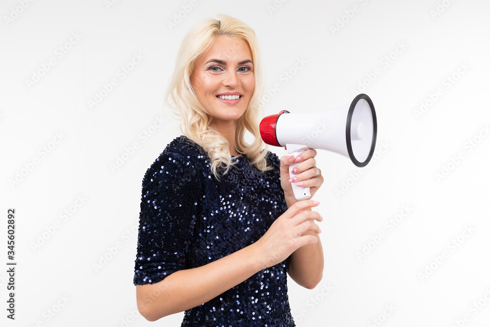 Wall mural blond girl with a loudspeaker in hand screaming about discounts sideways on a white background