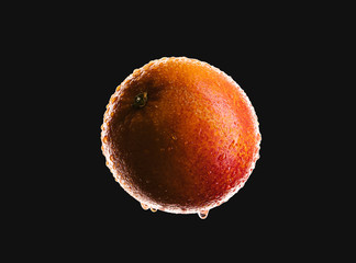 Macro of blood orange isolated on black background. Dark and moody food concept