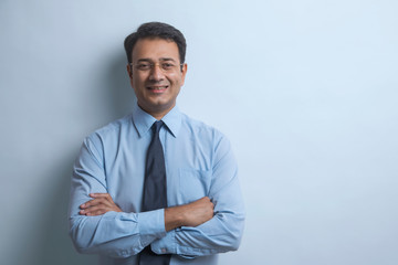Portrait of a businessman in eyeglasses standing with arms crossed

