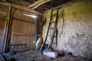 Color photo. Tint green. Old abandoned barn in the village. Inside the retro staircase leads to the...