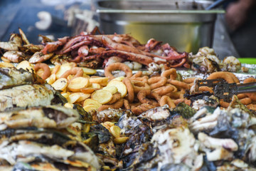 Freshly grilled fish on counter top stall, during seafood festival, street food market.