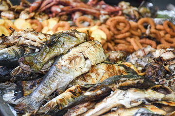 Freshly grilled fish on counter top stall, during seafood festival, street food market.
