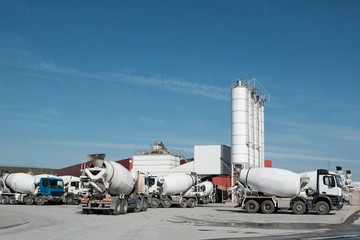 White concrete mixers standing by a modern concrete plant.
