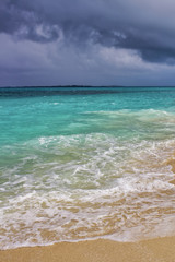 Fototapeta na wymiar Waves crushing on the shoreline on a tropical beach. Vacation concept