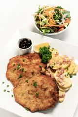 german breaded organic pork schnitzel with bacon fried potatoes