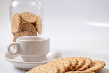 white cup of coffee with cookies on background