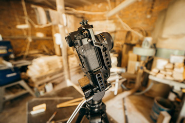 Camera set up on tripod recording production in carpentry