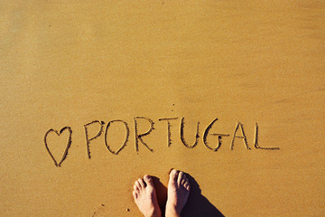 Man Standing on Top of a Carved Love Portugal on the Sand