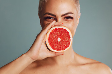 Woman holding a grapefruit against her mouth