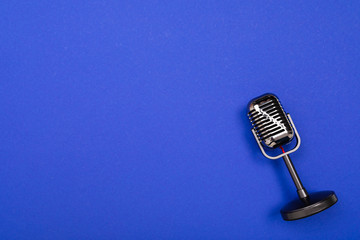 Black microphone isolated on blue background