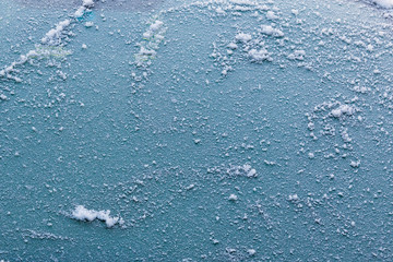 Frosty winter background with a place to copy. Crystals of snow and ice on frozen glass. Low temperatures and icing.