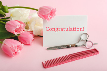 Congratulation text on card fom hairdresser, beauty salon. Beauty services. White blank card with space for text, mock up, hairdressing scissors comb in bouquet of pink tulips on pink background