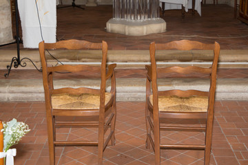 Fototapeta na wymiar two empty chairs in church before wedding celebration