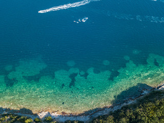 Aerial view of watercraft, jagged and lush coasts. Mediterranean scrub. Sea, crystal clear water. Sveti Nikola, Budva island, Montenegro