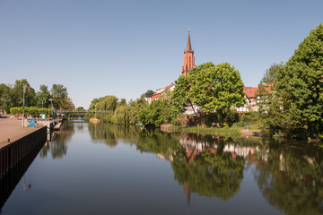 Fototapeta na wymiar St. Marien-Andreas church at the city canal at the old harbour in Rathenow 