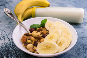 Granola with banana and milk on the table. Close-up. Delicious and healthy breakfast.