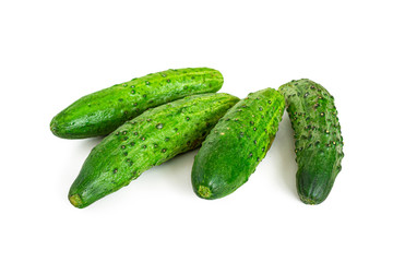 Group of four green cucumbers on a white background