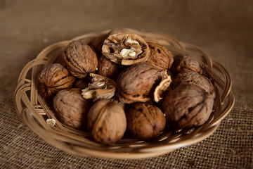 walnut in a wicker plate on a brown background