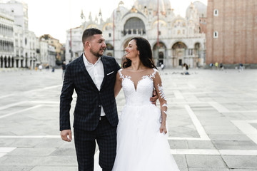 happy bride and groom cuddle during a wedding walk,lovely couple's wedding day,beautiful outfits of the newlyweds,