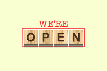 We are open. The inscription on wooden blocks on a pastel green background. Concept of opening a business after quarantine. Business.