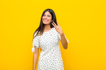 young pretty latin woman smiling and looking friendly, showing number three or third with hand...