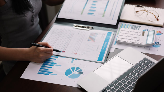 Working from home, Corona virus protection, Closeup business woman using laptop computer and analyzing financial report, Woman in quarantine for coronavirus wearing protective mask