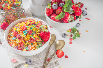 Colorful fruit cereal flakes. Multicolored fruit breakfast corn flakes, with various fruit taste, with milk and fresh berries on white table. Traditional american morning snack