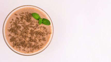 
Chocolate milkshake in a glass on a white background. View from the top. Copy space.