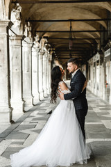 Fototapeta premium happy bride and groom cuddle during a wedding walk,lovely couple's wedding day,beautiful outfits of the newlyweds,