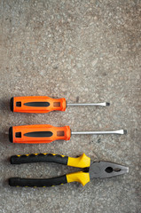 Pliers and screwdriverts on gray background