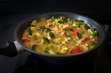 Gemüsepfanne, Hühnchenpfanne, Thai Curry mit frischem Gemüse und Fleisch in einer Pfanne mit Kurkuma und Ingwer
