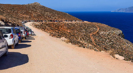 Landscape with a lot of parked cars, road to Balos Beach, Crete, Greece. 