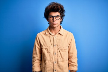 Young handsome man wearing casual shirt standing over isolated blue background skeptic and nervous, frowning upset because of problem. Negative person.