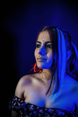 Naklejka premium ethnic girl on a black background in blue light