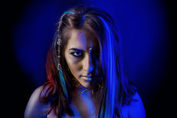 Naklejka premium ethnic girl on a black background in blue light