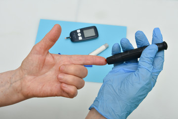 Close up of woman hands using black  lancet on finger to check blood sugar level 