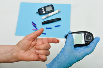 Doctor checking blood sugar level with glucometer. 
