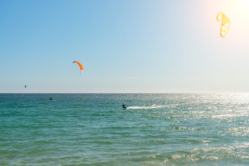 The athlete practices kate board surfing the sea on the waves. Summer in Portugal Algarve.