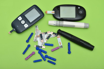 2 Diabetes set with glucometer, lancet, spare needles on green background 
