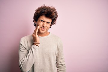 Fototapeta na wymiar Young handsome man wearing casual t-shirt standing over isolated pink background touching mouth with hand with painful expression because of toothache or dental illness on teeth. Dentist