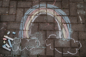 Regenbogen mit Straßenkreide gemalt in Covid-19 Zeiten Hoffnung auf bessere Zeiten, Wolken...