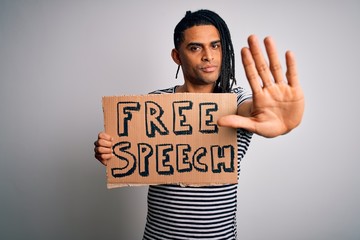 Young african american man with dreadlocks holding banner with free speech message protest with open hand doing stop sign with serious and confident expression, defense gesture