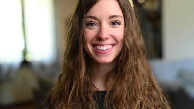 Giovane bella ragazza sorride in camera a casa